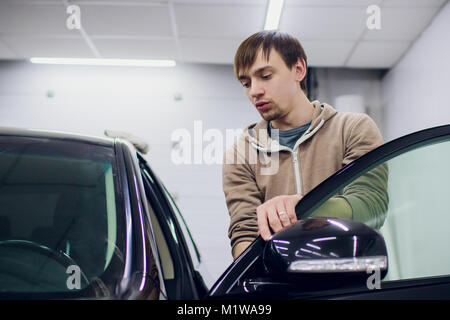Auto Spiegel Mann, Reparatur, Autounfall gebrochen Seite Spiegel. Schwarz Stockfoto