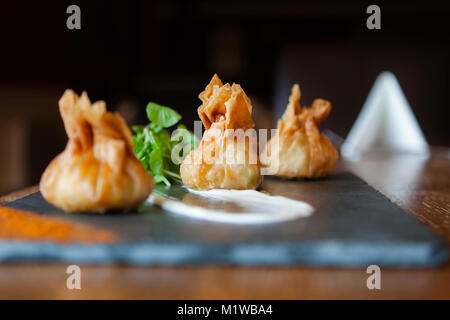 Wontons auf einer Schiefertafel Platte in einem Restaurant. Stockfoto