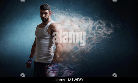 Muskulöse männliche Boxer stehend über dunklen Hintergrund Partikel Effekt. Stockfoto
