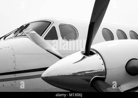General Aviation Business Flugzeuge an einem bewölkten Tag mit festem, bewölktem Hintergrund in Schwarz und Weiß Stockfoto