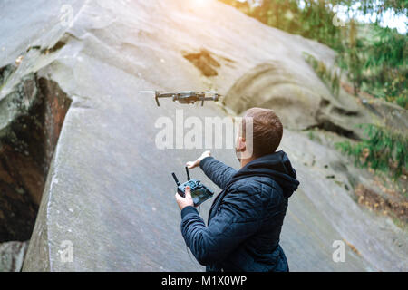 Guy startet einen quadrocopter im Wald Stockfoto