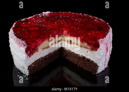 Stück einen großen Kuchen in Kokos Späne mit Erdbeeren in Gelee auf schwarzem Hintergrund Stockfoto