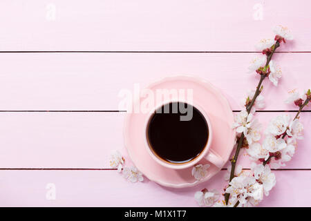 Tasse Kaffee und Blumen auf rosa Holztisch. Stockfoto