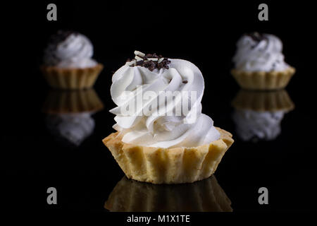 Kuchen mit Protein Creme auf einem schwarzen Hintergrund. Kuchen Körbe Stockfoto