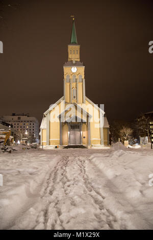 Tromsø Kathedrale (Tromsø Domkirke), mit Schnee und Abdrücke in den Vordergrund, sitzt vor einem dunklen Himmel während der Polarnacht in Tromsø, Norwegen. Stockfoto