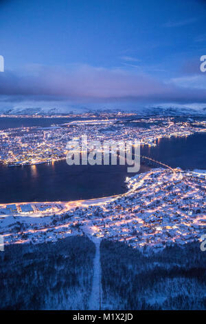 Eine horizontale Foto von Tromsø, Norwegen beleuchtet im Winter während der polarnacht wie oben von einem nahe gelegenen Berg an der Seilbahn Fjellheisen stop gesehen. Stockfoto