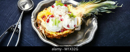 Eis in einer Ananas Vase, dekoriert mit Kiwi und Granatapfel Stockfoto
