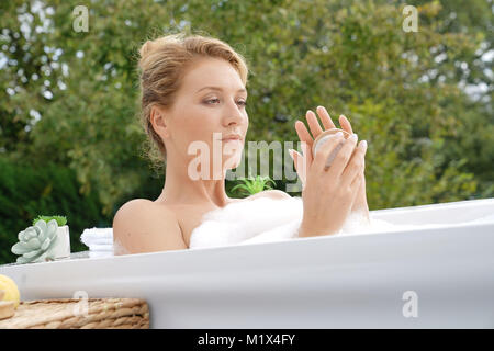 Schöne Frau in Badewanne und mit Nailbrush Stockfoto