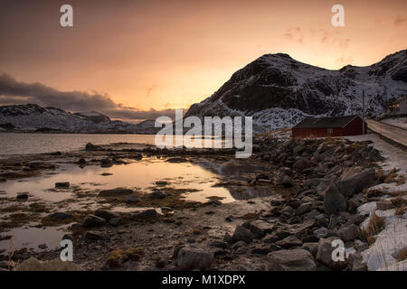 Sonnenaufgang über schneebedeckte Landschaft, die von der E10 Flakstadøya auf den Lofoten in Norwegen Stockfoto