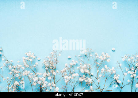 Kleine weiße Gypsophila Blüten auf blauem Hintergrund, schönen floralen Grenze, Ansicht von oben, Kopieren, horizontal Stockfoto