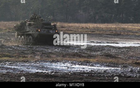 Us-Soldaten von Kronos Truppe, 3 Staffel, 2. Kavallerie Regiments, fahren ihre Stryker zu ihrem Kampf so positionieren, wie sie sich in einem angebauten NATO live fire Übung von der Polnischen 1. Bataillon 15 mechanisierte Brigade in einem Bereich in der Nähe der Bemowo Piskie, Polen, Jan. 30, 2018 koordinierte teilnehmen. Die einzigartige, multinationalen Battle Group, bestehend aus USA, Großbritannien, Kroatischen und Rumänische Soldaten dienen, die mit der polnischen 15 mechanisierte Brigade als Abschreckung Kraft im Nordosten Polens in der Unterstützung der NATO-Präsenz verstärkt nach vorne. (U.S. Armee Stockfoto