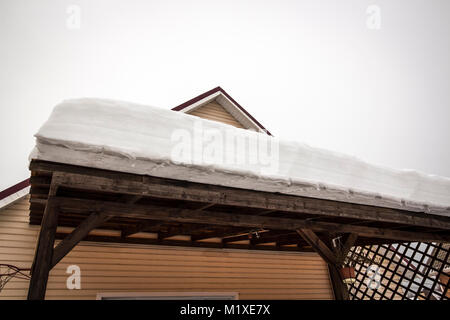 Eine dicke Schicht von Schnee auf dem Dach einer Holzterrasse. Stockfoto