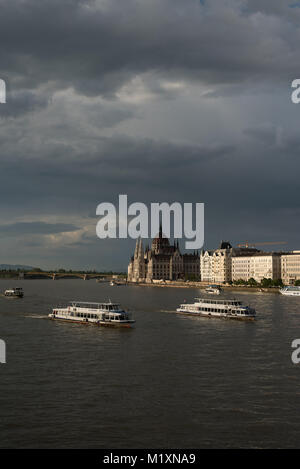 Die grauen Wolken über Donau voller fahren Boote. Querformat von Budapest, Ungarn. Stockfoto