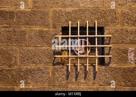 Alte Steinmauer und vergitterten Fenster während der Nacht Stockfoto
