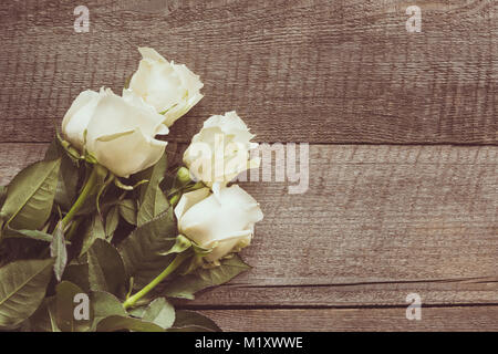 Weich ausgewachsenen weißen Rosen als neutraler Hintergrund auf Holzbrett. Getönten Bild. Ansicht von oben. Kopieren Sie Platz. Stockfoto