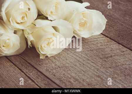 Weich ausgewachsenen weißen Rosen als neutraler Hintergrund auf Holzbrett. Selektive konzentrieren. Getönten Bild. Stockfoto