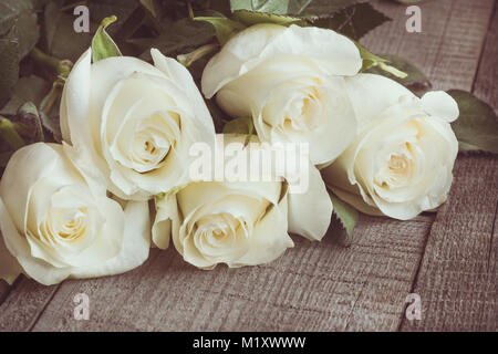 Weich ausgewachsenen weißen Rosen als neutraler Hintergrund auf Holzbrett. Selektive konzentrieren. Getönten Bild. Close Up. Stockfoto