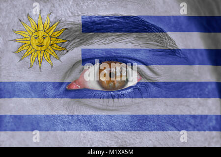 Menschliches Antlitz und ein menschliches Auge gemalt mit Flagge Uruguay Stockfoto