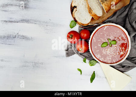Heiße Tomatensuppe mit Parmesan und Basilikum. Bild geschossen von oben im flachen Stil legen. Stockfoto