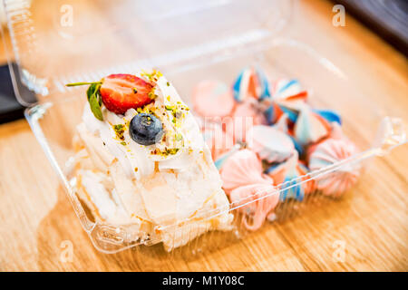 Scheibe der Swiss roll und bunten meringue Küsse Stockfoto