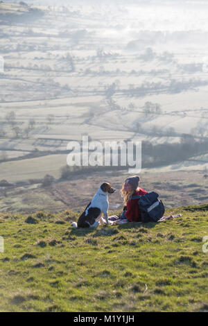 Großbritannien, Derbyshire, ein Walker und ihr Hund, bewundern Sie die Aussicht auf Hoffnung Tal von Mam Tor. Stockfoto