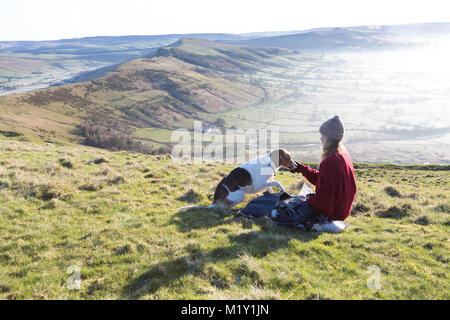 Großbritannien, Derbyshire, ein Walker und ihr Hund, bewundern Sie die Aussicht über entlang Mam Tor Ridge. Stockfoto