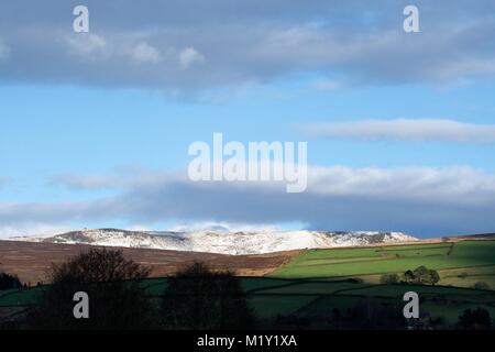 Eine verschneite Kinder dominiert die Skyline von Birch Vale, Derbyshire gesehen. Stockfoto