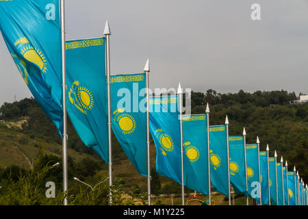 Linie der blauen und gelben Kasachische Fahnen im Wind, Almaty, Kasachstan, Asien. Stockfoto