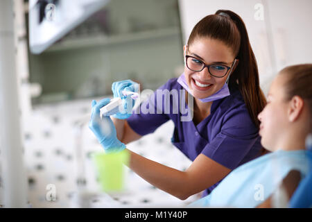 Weiblichen Zahnarzt zeigen, wie jungen Patienten richtig Bürste Zähne auf Spannbacken Stockfoto