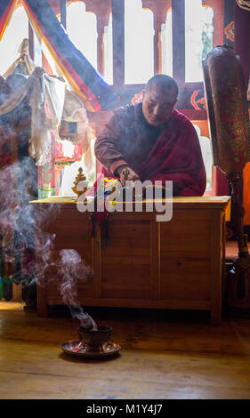 Paro, Bhutan. Buddhistischer Mönch Lesen der Heiligen Schriften in seinem Tempel, der Druk Choeding Tempel von Paro. Stockfoto