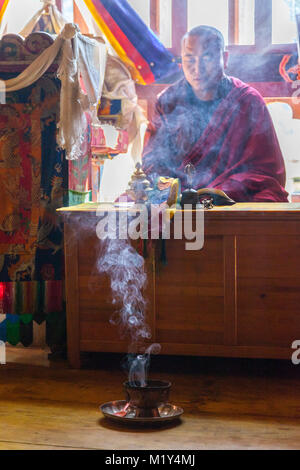 Paro, Bhutan. Buddhistischer Mönch Lesen der Heiligen Schriften in seinem Tempel, der Druk Choeding Tempel von Paro. Stockfoto