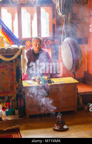 Paro, Bhutan. Buddhistischer Mönch Lesen der Heiligen Schriften in seinem Tempel, der Druk Choeding Tempel von Paro. Stockfoto