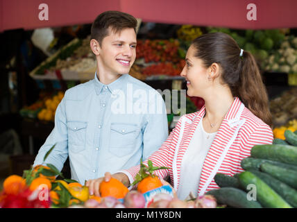 Freudige junge Paar Auswahl von Obst und Gemüse auf dem Markt Stockfoto