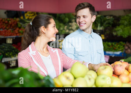 Fröhlich lächelnd junges paar Sie Obst und Gemüse auf dem Markt Stockfoto