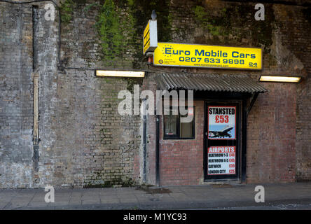 Ein Taxi office Werbung Flughafen Messen unter einem viktorianischen Brücke in der Nähe der Waterloo Station, am 30. Januar 2018, im Süden Londoner Stadtteil Southwark, England. Stockfoto