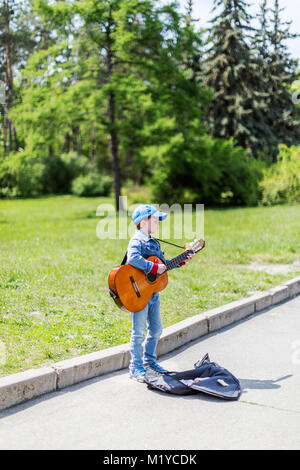 Kiew, Ukraine 01.Mai 2016. Junge spielt auf der Akustikgitarre im Freien. Kleine Straße Musiker Stockfoto