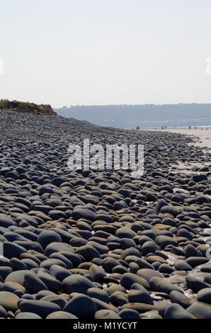 Blaue abgerundete Boulder Strand von Westward Ho! Seascape Beach, North Devon, Großbritannien. Stockfoto