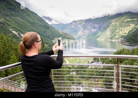 Frau, ein Foto mit ihr Smartphone vor der majestätischen Blick auf einen Fjord in Norwegen. Stockfoto