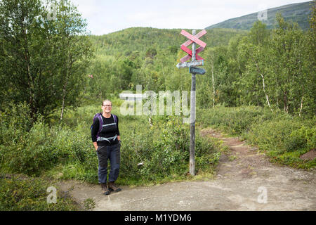 Weibchen mit Rucksack auf einem Schild am Wanderweg der Kungsleden in Lappland, Schweden. Stockfoto