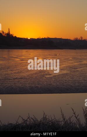 Orange Winter Sonnenaufgang über dem Fluss Clyst, Exe Estuary bei Ebbe. Topsha, Exeter, Devon, Großbritannien. Dezember, 2014. Stockfoto