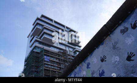 BERLIN, DEUTSCHLAND - Jan 17th, 2015: Die Berliner Mauer und neue Hohes Apartmentgebäude an der East Side Gallery Stockfoto