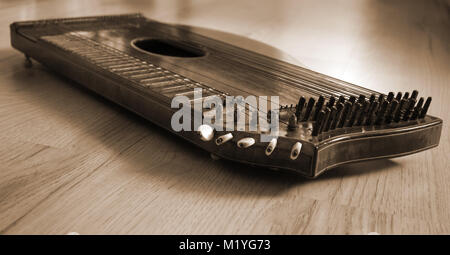 Alte zither liegen auf einem Holztisch in braun Farbe. Stockfoto