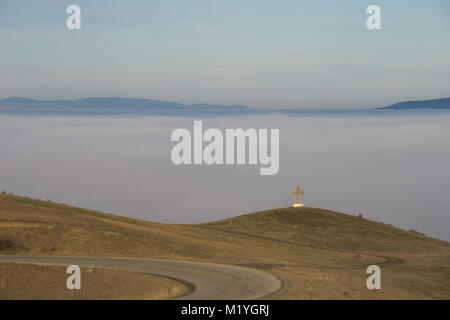 Kreuz aus Holz mit Blick auf eine neblige Tal in der Rumänischen Provinz Siebenbürgen Stockfoto