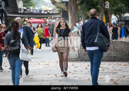 LONDON, ENGLAND - 22. AUGUST 2017 ein Mädchen in eine schwarze Bluse und eine kurze Leopard Rock ist einen Spaziergang entlang der South Bank Stockfoto