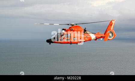 Der Küstenwache MH-65 Dolphin helicopter Crew von Air Station Port Angeles fliegen der Straße von Juan de Fuca, vor der Küste von Washington, Jan. 26, 2018. Air Station hat drei Dolphin Hubschrauber und ist verantwortlich für die Suche und Rettung Antwort über die nördliche Küste Washington. U.S. Coast Guard Foto von Chief Petty Officer David Mosley Stockfoto