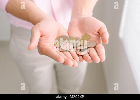 Handvoll Münzen, die in der Palme männlichen Händen Stockfoto