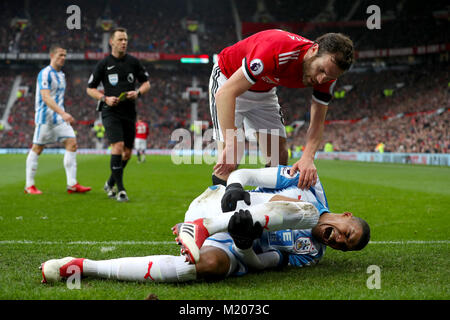 Die Huddersfield Town Collin Quaner Kupplungen sein nach einer Herausforderung, die von Juan Mata von Manchester United in der Premier League Spiel im Old Trafford, Manchester. Stockfoto