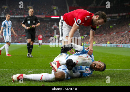 Die Huddersfield Town Collin Quaner Kupplungen sein nach einer Herausforderung, die von Juan Mata von Manchester United in der Premier League Spiel im Old Trafford, Manchester. Stockfoto