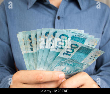 Geld aus Brasilien. Noten von Real, die brasilianische Währung. Konzept der Finanzierung, Investitionen, Reichtum. Mann hält cash Rechnungen. Stockfoto