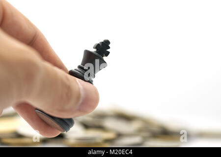 Geschäftsmann mit einem König Schach ist auf einem Haufen Münzen platziert. Verwendung als Hintergrund Business Konzept und Strategie konzept mit Platz für Ihren Text kopieren Stockfoto